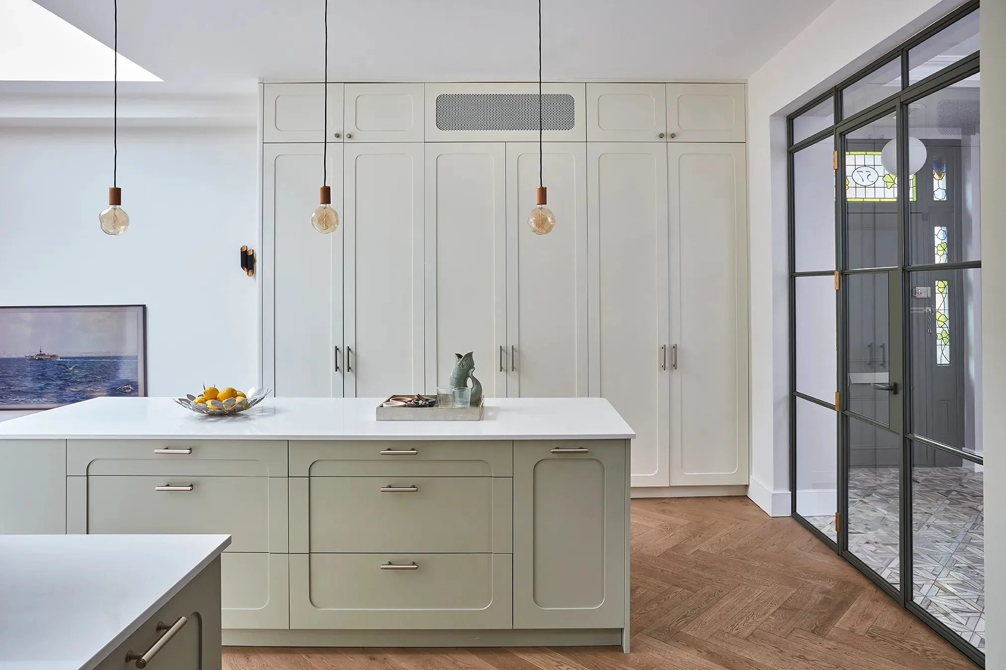 Pale green kitchen cupboards and island