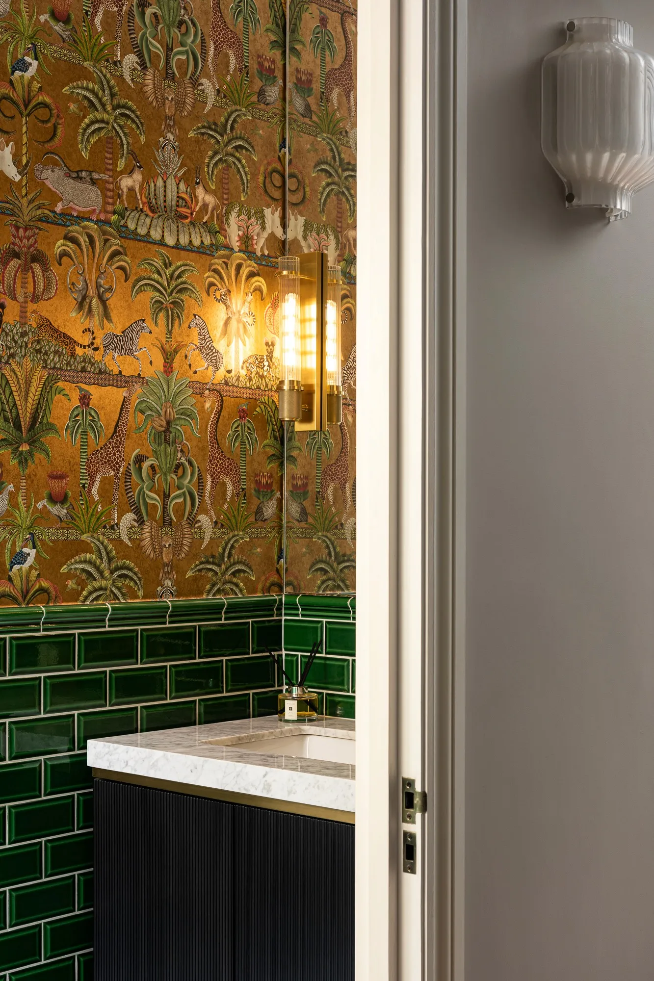 Cloakroom with patterned wallpaper and green tiles