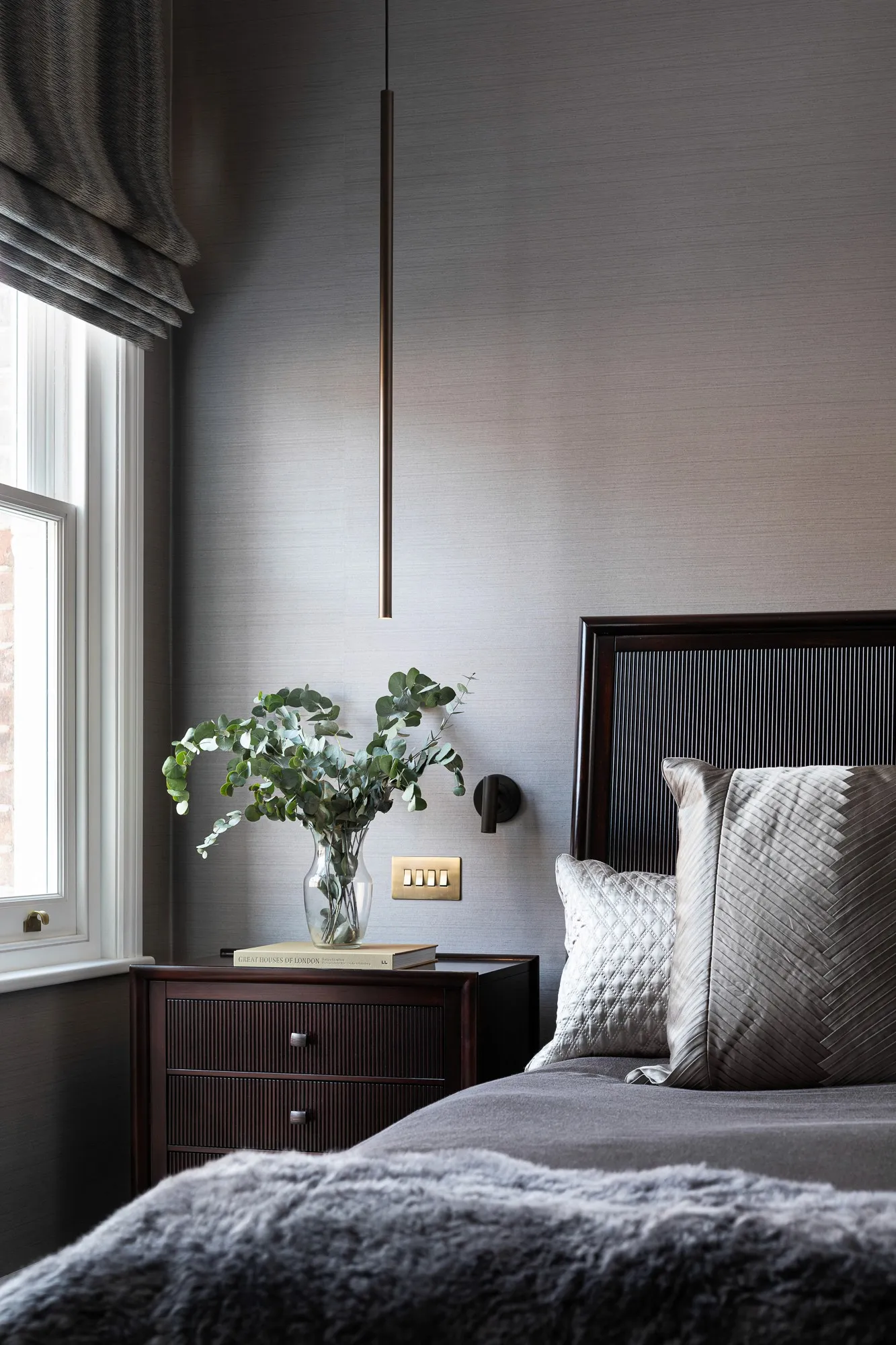 Bedroom with grasscloth walls and pendant light