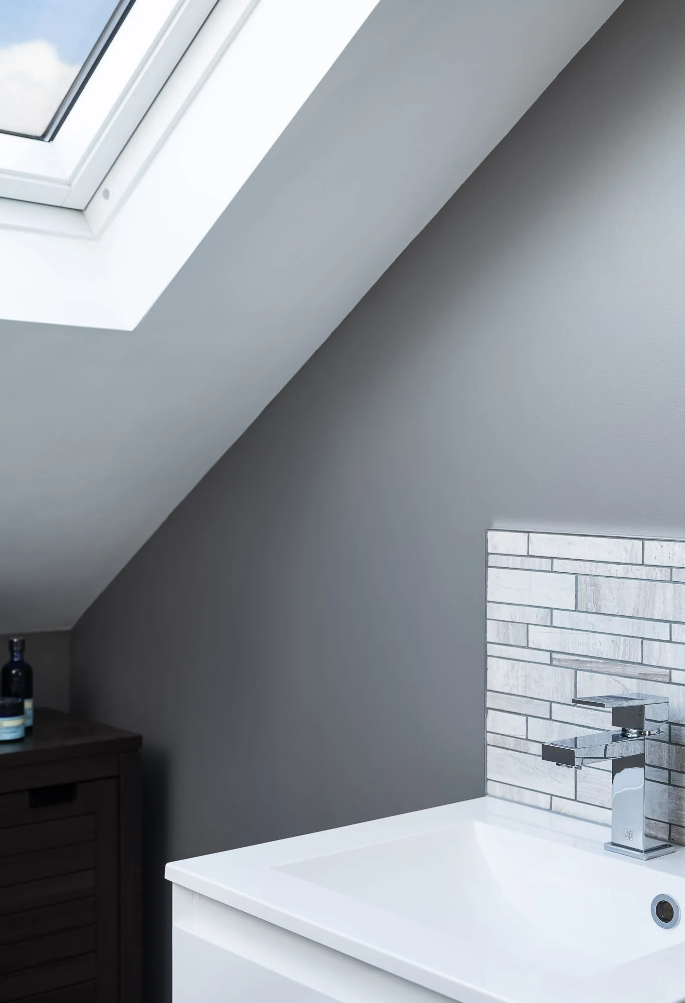 Basin against the sloped wall and brick splashback