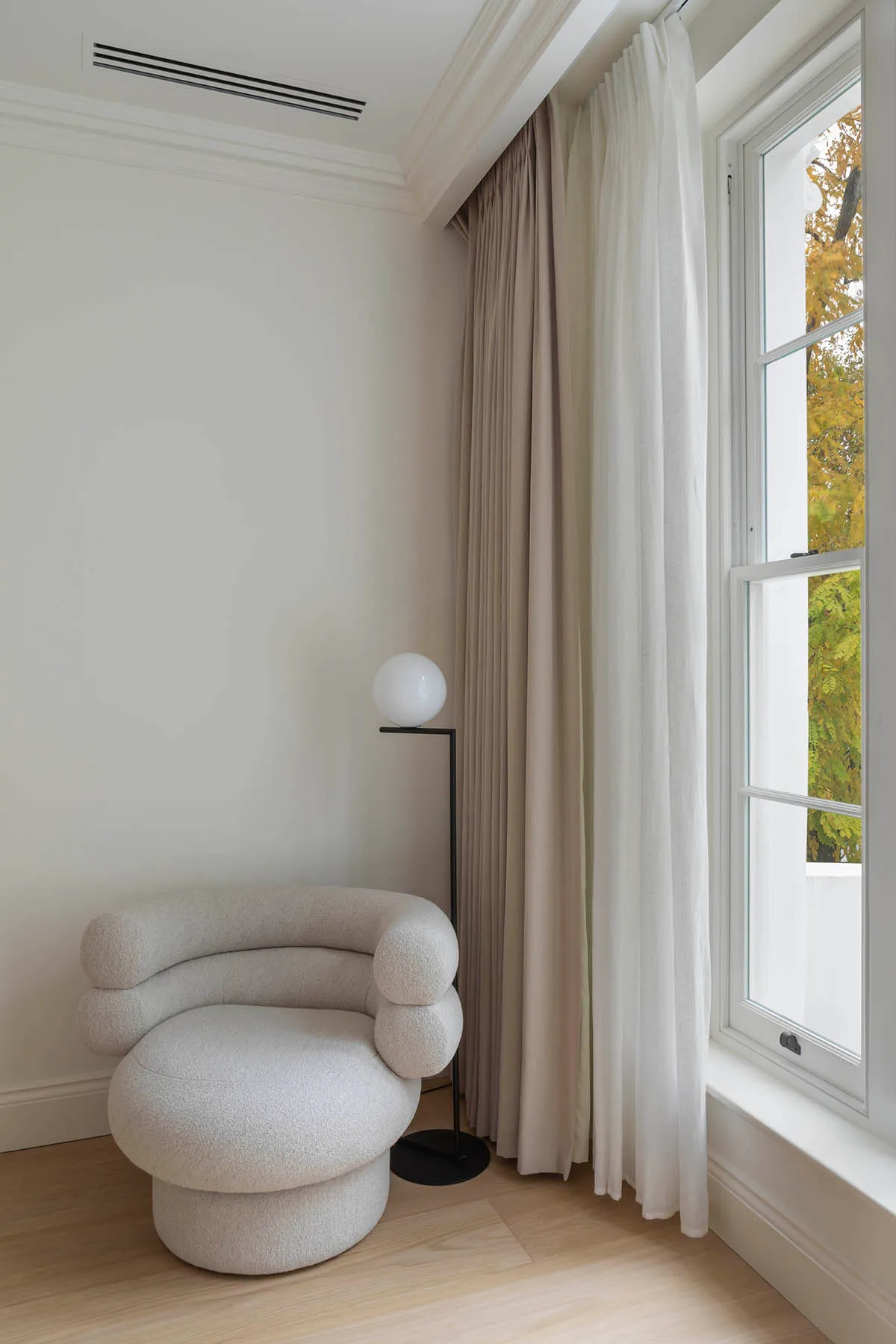 Armchair beside the tall bedroom window