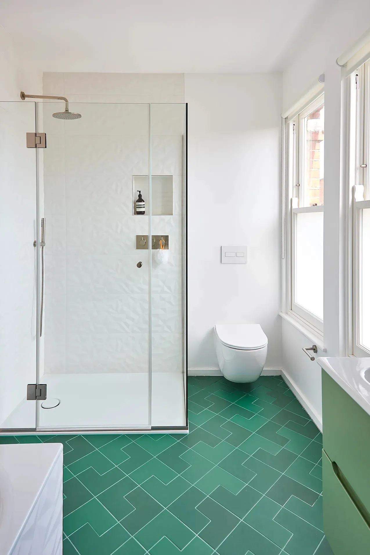 Shower and WC on green floor tiles