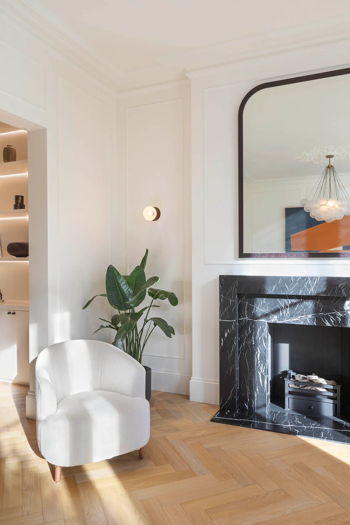 Armchair and mirror by the marble chimneypiece