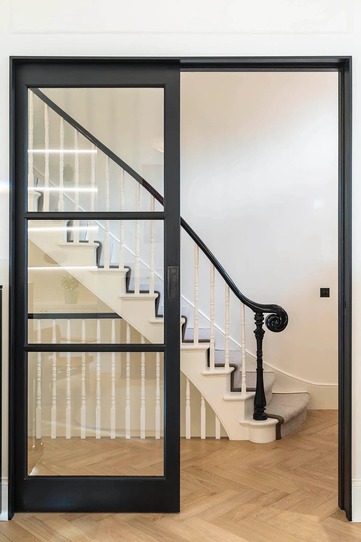 Glazed screen at the foot of the stair