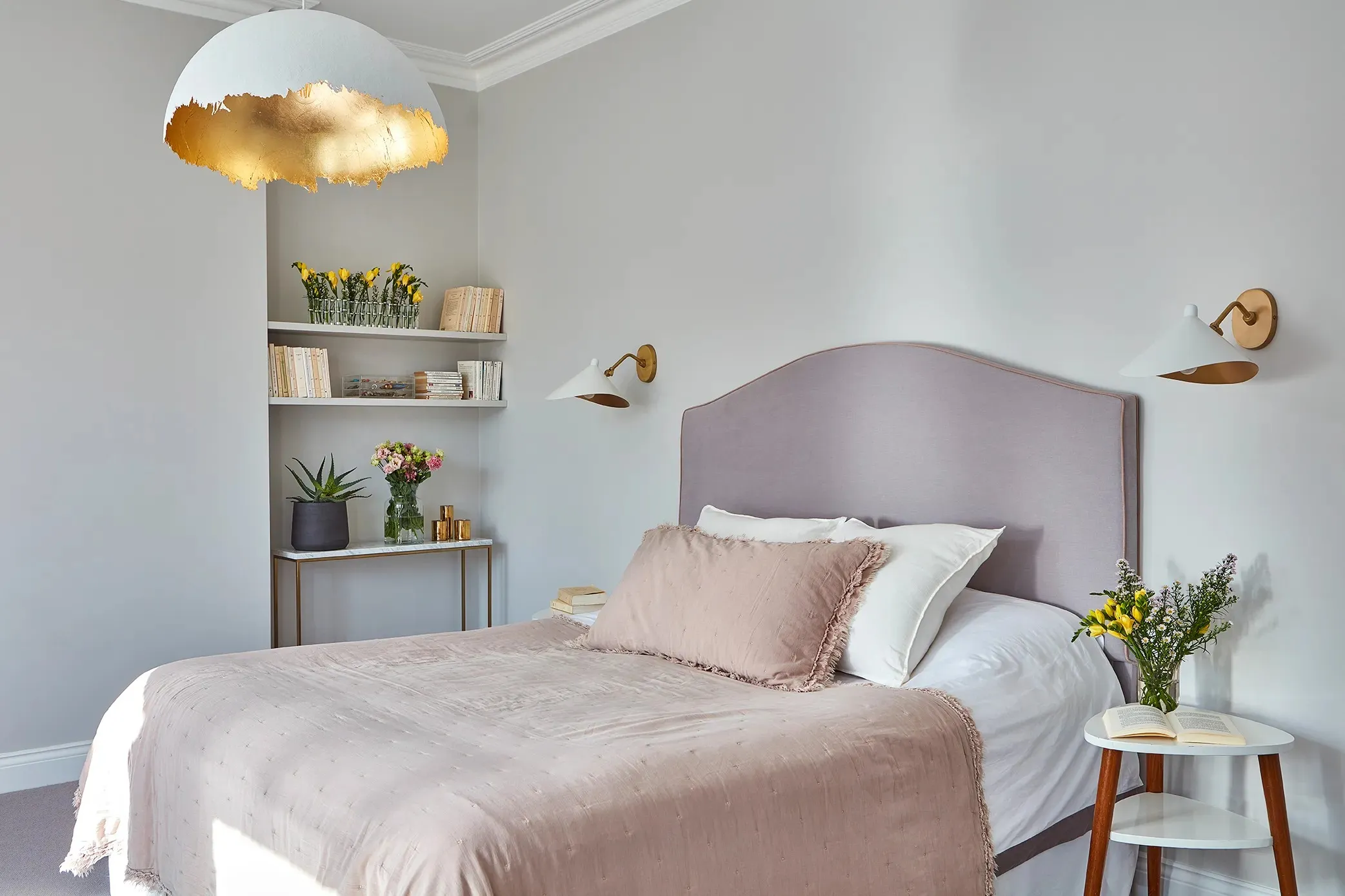 Bedroom with pale headboard and gold pendant