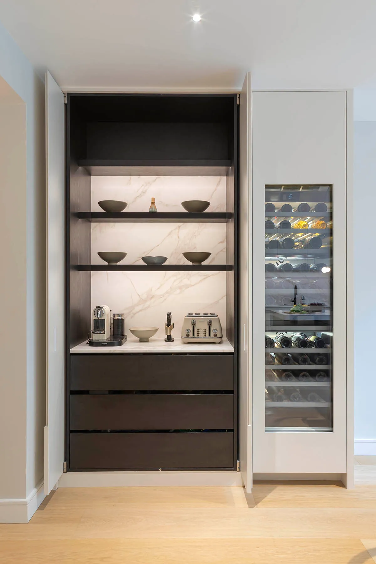 Coffee station and wine fridge behind tall doors