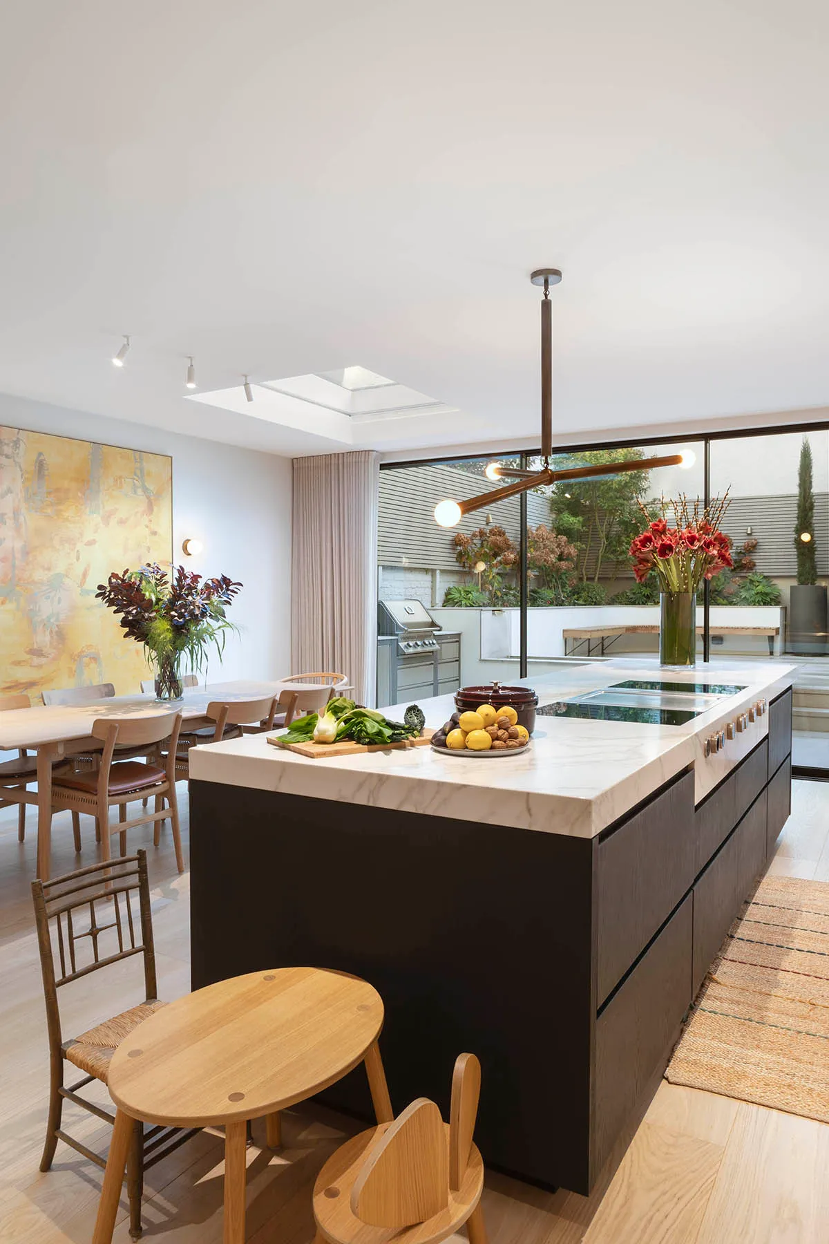 Dining table beyond the island and rooflight