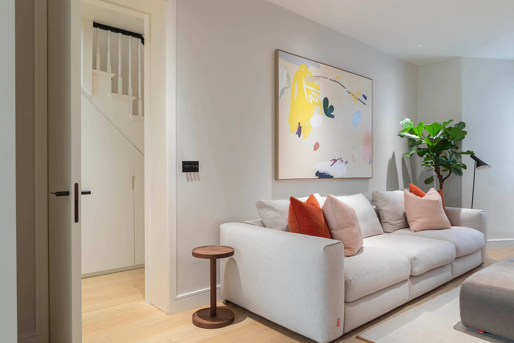 White sofa and artwork beside the stair door