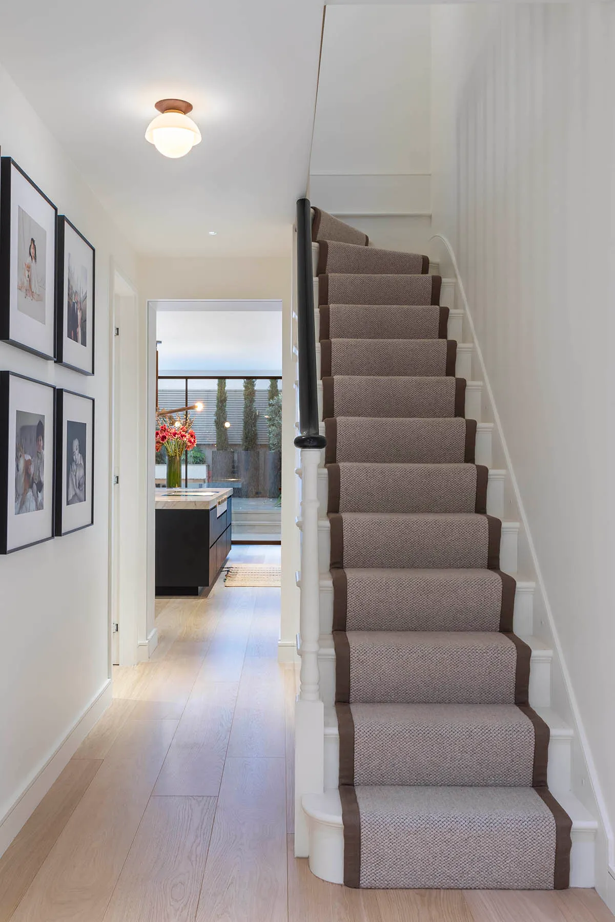 Stair runner and framed photographs in the hall